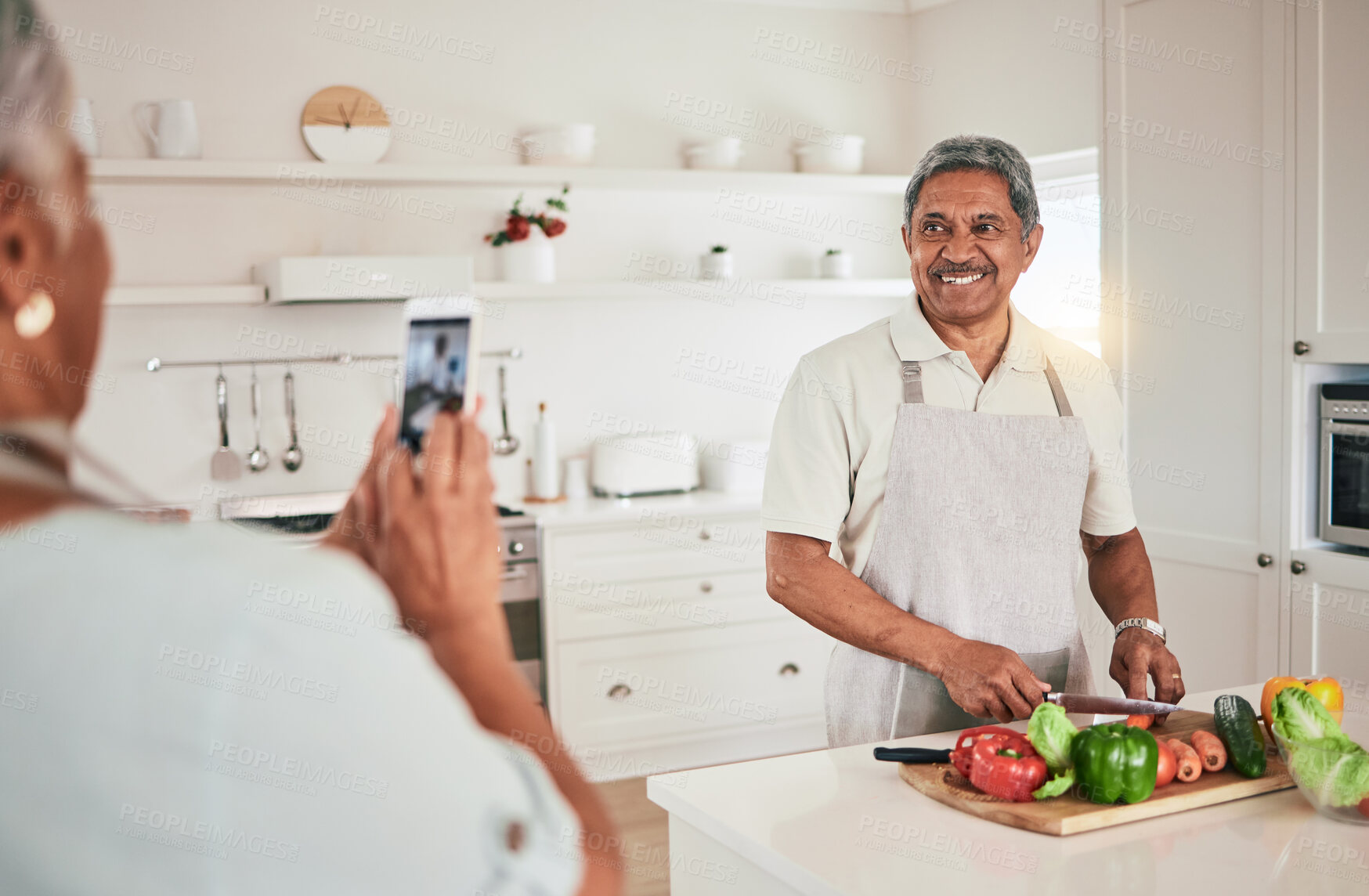 Buy stock photo Kitchen cooking, elderly couple or phone photo of senior man, husband or nutritionist person with memory picture. Vegan food, love or people bonding, happy or prepare vegetables ingredients for lunch