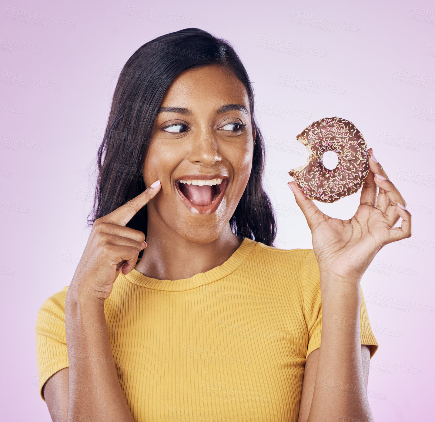 Buy stock photo Donut, dessert and bite with woman in studio for diet, snack and happiness. Sugar, food and smile with female eating sweets treat isolated on pink background for nutrition, excited and craving mockup