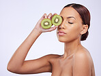 Beauty, skincare and kiwi with woman in studio for natural cosmetics, diet and nutrition. Product, glow and self care with female model and fruit on white background for spa, food and vitamin