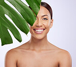 Portrait, leaf and woman in studio for skincare, dermatology and cosmetic on purple background. Beauty, face and girl model relax, smile and happy with glowing skin, cosmetology or monstera treatment