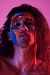 Beauty, cosmetics and portrait of man with paint for creative art, makeup and glow on studio background. Neon lighting, skincare and color on face of male model for fantasy, abstract and aesthetic