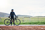 Woman, athlete and bicycle in countryside, mockup on sky and training for triathlon, sports and goals. Female cyclist, bike and fitness gear with motivation, freedom or thinking of cardio performance