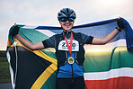 Winner sports, happy woman from South Africa with flag and gold medal winning, outdoor cycling race or triathlon. Happiness, win and cyclist with smile, fitness and world record with national pride.