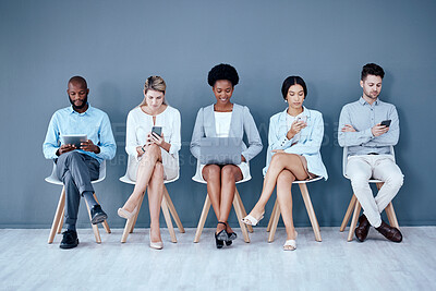 Buy stock photo Business people, networking and technology in waiting room for interview, meeting or job search at office. Diversity group of employees sitting in row for recruitment process, collaboration or hiring