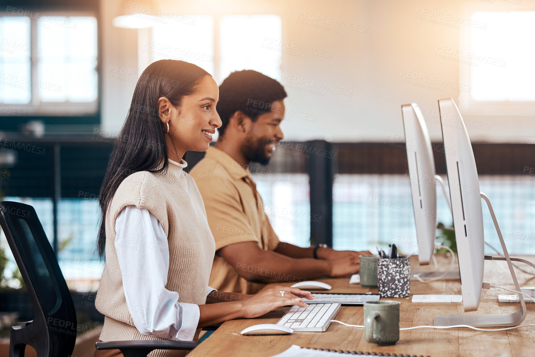 Buy stock photo Happy, coworking office and employees with a computer, working together and online communication. Smile, our vision and diversity with workers sitting at a desk typing on a pc for a corporate job