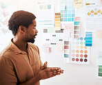Black man, color palette and planning in design, brainstorming or strategy on wall at office. Thoughtful Creative African male graphic designer looking at colors or ideas for project plan or startup