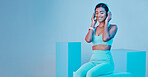 Mockup, fitness and woman with headphones, smile and exercise against a blue studio background. Female model, joy and person with headset, workout and streaming music with happiness, sports and radio