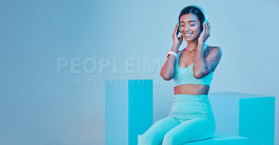 Buy stock photo Mockup, fitness and woman with headphones, smile and exercise against a blue studio background. Female model, joy and person with headset, workout and streaming music with happiness, sports and radio
