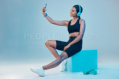 Buy stock photo Woman, fitness and selfie in studio with music, wellness or training clothes by background. Gen z model, influencer girl and fashion with streaming, profile picture or exercise for health with smile