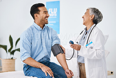 Buy stock photo Doctor, patient and blood pressure consultation in hospital while laughing and talking about health. Medical professional woman and man with cuff for hypertension, healthcare and wellness check