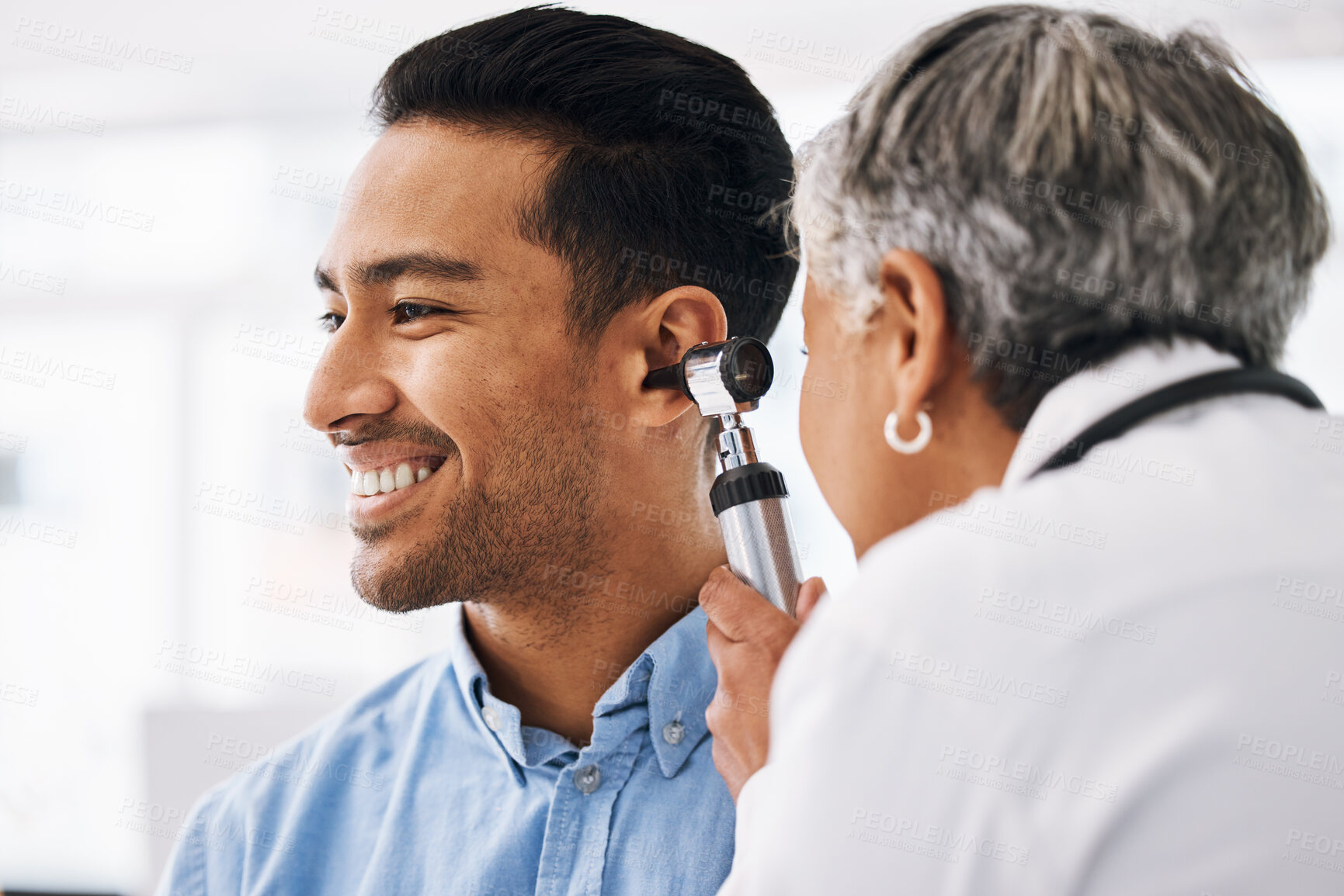 Buy stock photo Doctor check patient ear, healthcare and medical consultation at hospital with otolaryngology specialist. Happy man and physician woman with otoscope, test for hearing problem and health insurance