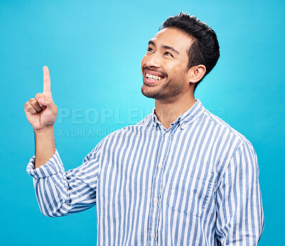 Point, thinking and man on blue background for news, information and announcement in studio. Advertising, mockup sign and face of excited male pointing for copy space, promotion and showing gesture