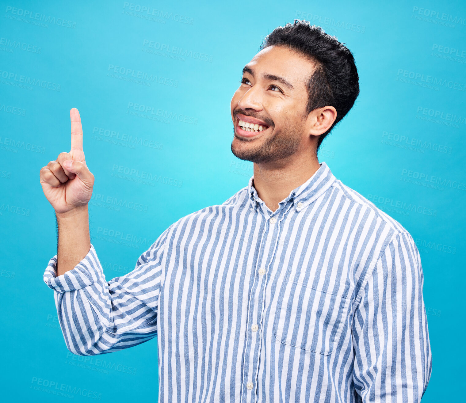 Buy stock photo Point, thinking and man on blue background for news, information and announcement in studio. Advertising, mockup sign and face of excited male pointing for copy space, promotion and showing gesture