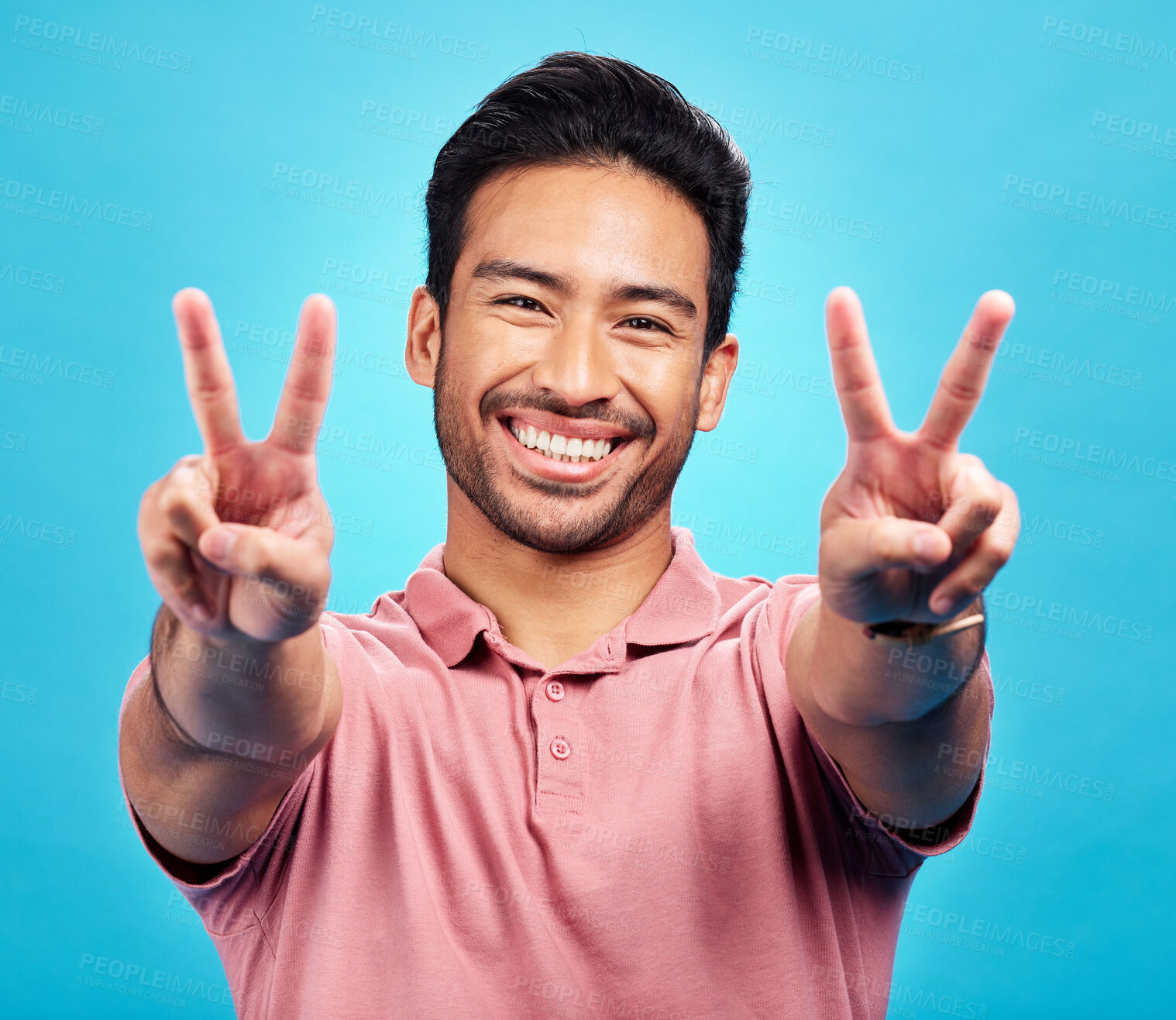 Buy stock photo Portrait, peace sign and Asian man with a smile, support and confident on a blue studio background. Face, male person or model with v gesture, emoji and symbol with happiness, hands and peaceful icon