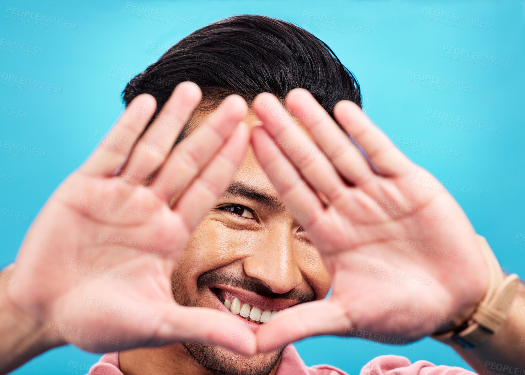 Buy stock photo Frame, hands and portrait of happy Asian man on blue background with smile, confidence and happiness. Perspective, shape and face of male person in studio for photography, profile picture and vision