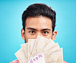 Man in portrait, money fan and cash with finance, prize or reward isolated on blue background. Financial savings, bonus or competition win with payment, male person with economic success in studio