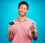 Man with smartphone, credit card and happy in portrait, ecommerce and fintech isolated on blue background. Online shopping, internet banking and finance, technology and male with bank app in studio