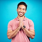 Happy, prayer hands and portrait of a man in a studio with a peaceful, positive and good mindset. Happiness, smile and face of a male model with a grateful hand gesture isolated by a blue background.