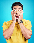 Wow, man and shocked at surprise in studio with announcement, hands on face and mouth open. Male model person on a blue background while scared or thinking of gossip, news or sale with comic emoji