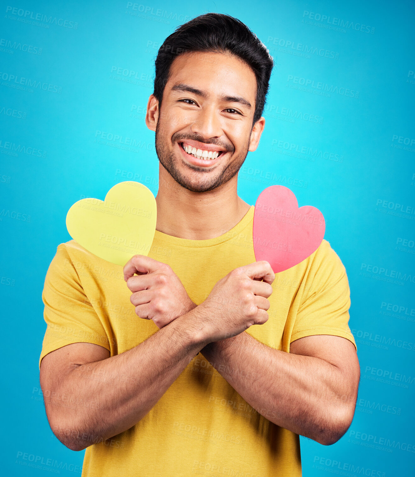 Buy stock photo Portrait, smile and man with heart cutout in studio isolated on a blue background. Love, happiness and Asian person with symbol, sign or emoji for affection, care and romance, empathy and valentines.