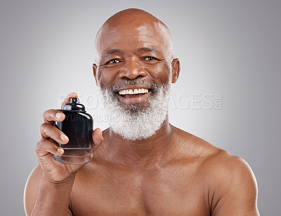 Buy stock photo Perfume, smile and portrait of senior black man model feeling happy and excited isolated in a gray studio background. Self care, skincare and old male person holding cologne for fragrance in backdrop