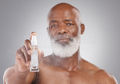 Buy stock photo Portrait, beauty and serum with a senior man holding an antiaging product in studio on a gray background. Face, skincare and cosmetics with a mature male spraying a facial treatment for beard care