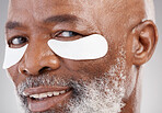 Skincare, collagen eye mask and portrait of black man with smile, happiness and anti ageing spa treatment.  Dermatology, cosmetic process and happy, mature model with patches on eyes for skin care.