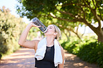 Fitness, runner or woman drinking water in park to hydrate, relax or healthy energy on exercise break in nature. Tired thirsty girl athlete refreshing with liquid for hydration in training or workout