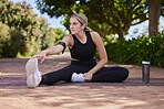 Thinking, stretching and a woman in a park for running, fitness preparation and morning cardio. Serious, sports and an athlete runner with a warm up on the ground before exercise training in nature