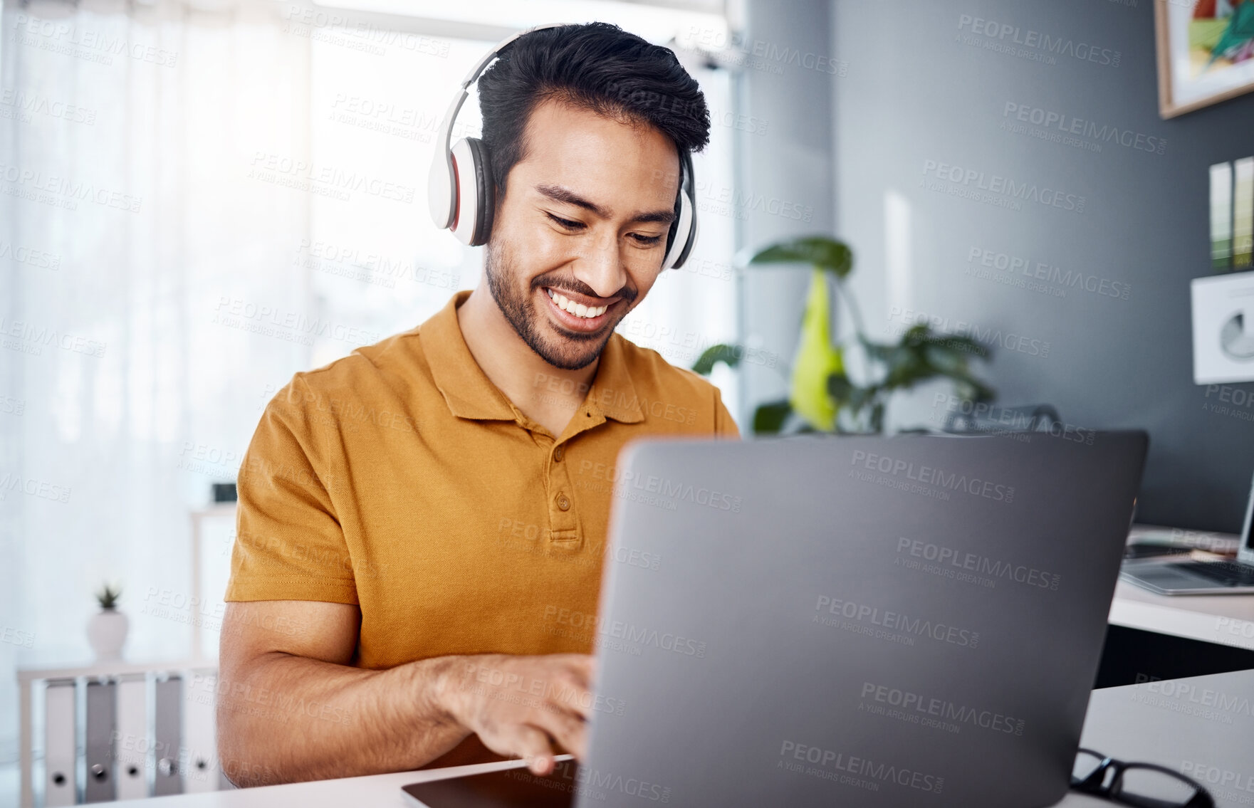 Buy stock photo Man is working from home, laptop and headphones while listening to music, happy and busy at desk. Male copywriter typing, freelance and blogger with remote work, technology and online audio streaming
