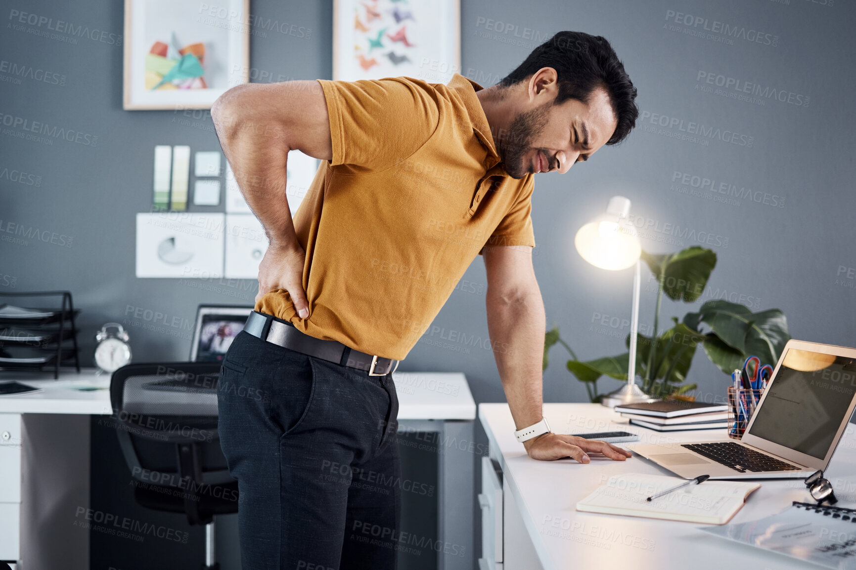 Buy stock photo Night, back pain and business man with stress at office desk in a modern workplace. Professional asian male person with health, body ache or burnout problem while tired, injured and working late