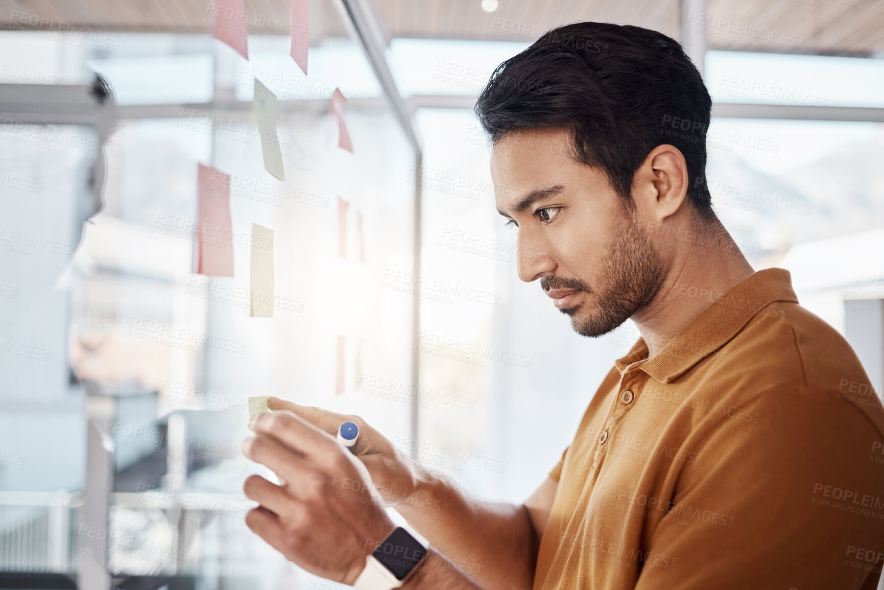 Buy stock photo Business man, sticky note and planning on glass board, writing and focus in startup workplace. Young businessman, moodboard and brainstorming with research, goals and ideas for solution in office