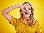 Portrait, happy woman and okay on eyes for good review,  motivation and sign on yellow background. Female person, funny face and ok hands for agreement, support and yes to emoji, thank you or winning