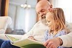 Grandfather, child and family reading on a living room sofa with love and learning support. Happy, home and kid with an elderly man in a house with a story book and youth education on a couch