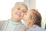 Kiss, care and child kissing grandmother on the cheek as love, happiness and support for family in a home. Smile, bonding and kid showing affection for a senior woman or grandma as gratitude