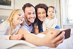 Family, selfie and smile in a home bedroom with children and parents together on bed for quality time. Man and woman of mother and father with children for a happy profile picture or memory for love