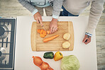 Cooking, vegetables and hands cook food in a kitchen for healthy, vitamins and nutritions diet in a home. Meal, overhead and people preparing fresh produce together on a chopping board for dinner