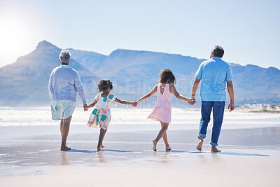 Buy stock photo Back, holding hands and grandparents at the beach with children for holiday and walking by the sea. Content, summer and girl kids on a walk by the ocean with a senior man and woman for bonding