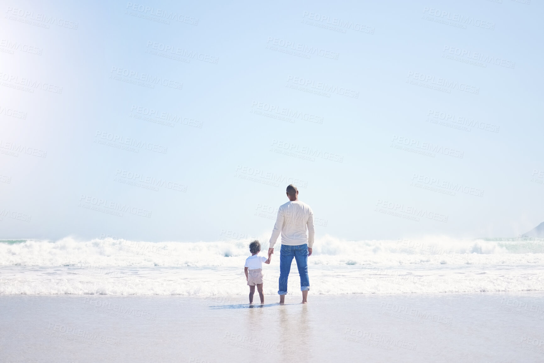 Buy stock photo Father, son and beach with back, space and mock up with blue sky, lens flare and bonding with love in summer. Papa, male kid and holding hands for care, vacation and sea mockup with waves in sunshine