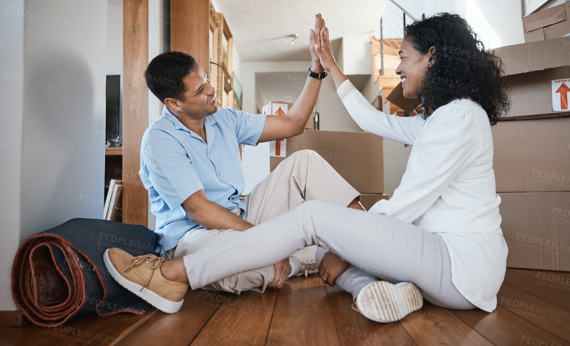 Buy stock photo High five, couple and moving home with success and happiness from buying real estate. Happy, young people and motivation hand gesture for target and goal of a new house purchase sitting on a floor