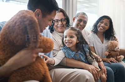 Buy stock photo Big family, parents and girl with teddy bear on couch, grandparent and smile for game in home living room. Men, women and female child with toys, love and happiness on lounge sofa in house on holiday