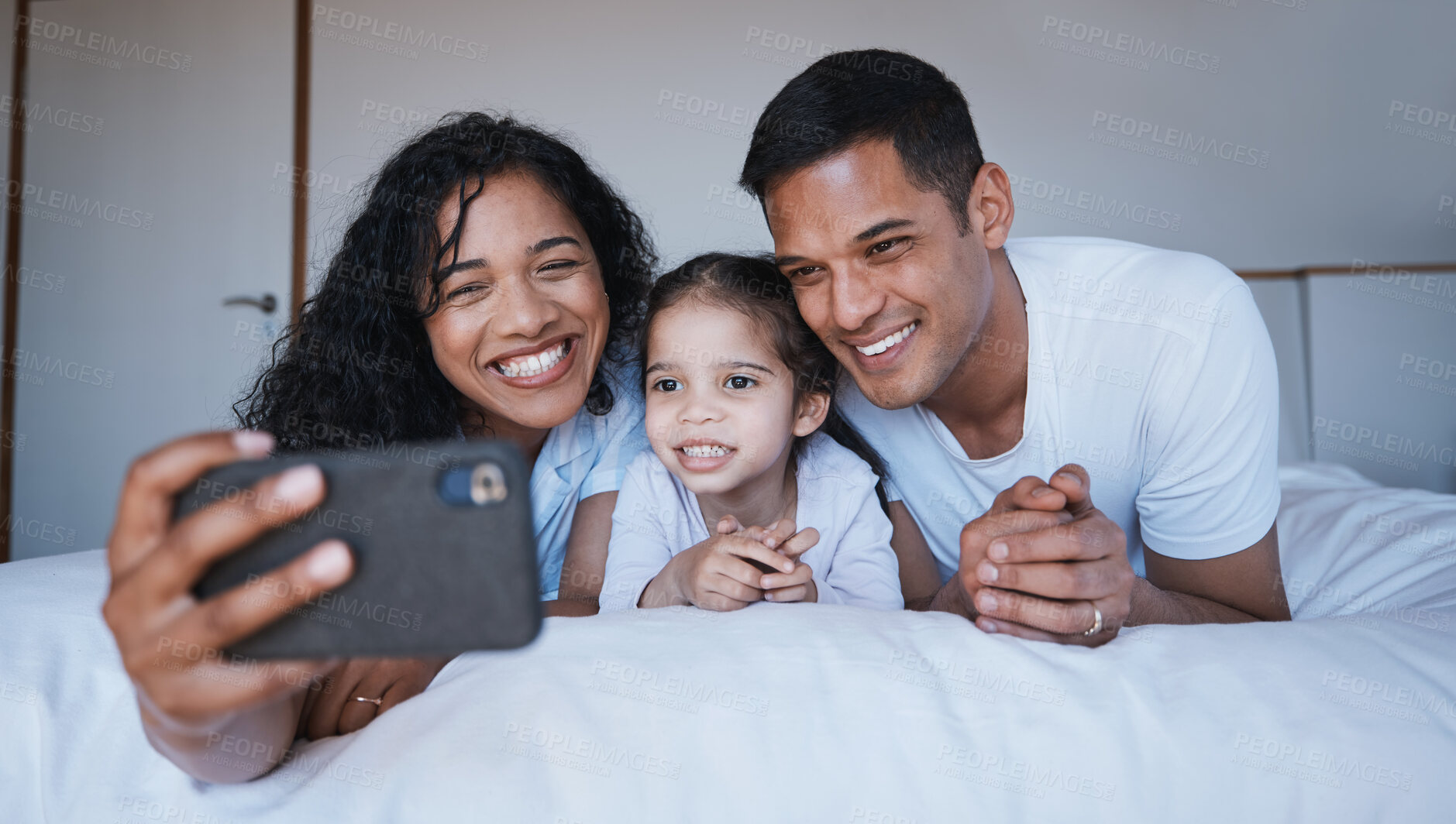 Buy stock photo Smile, family and selfie on bed in bedroom, bonding and having fun together. Photo, happiness and kid, mother and father taking pictures for social media, happy memory and profile picture in house.
