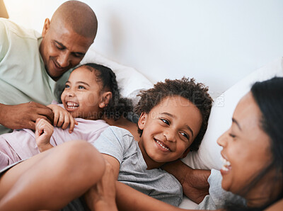Buy stock photo Happy family, relax and playing in the morning on bed with smile for free time, weekend or fun holiday at home. Mother, father and children relaxing and laughing together for playful joy in bedroom