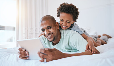 Buy stock photo Happy father, child and watching on tablet in bed for fun streaming or entertainment together at home. Dad, son or kid with smile relaxing with technology for movie, series or education in bedroom