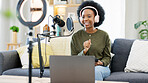 Cool journalist using digital tablet, talking into microphone and hosting podcast or broadcasting news while wearing headphones. Excited young woman using technology to promote on air from home