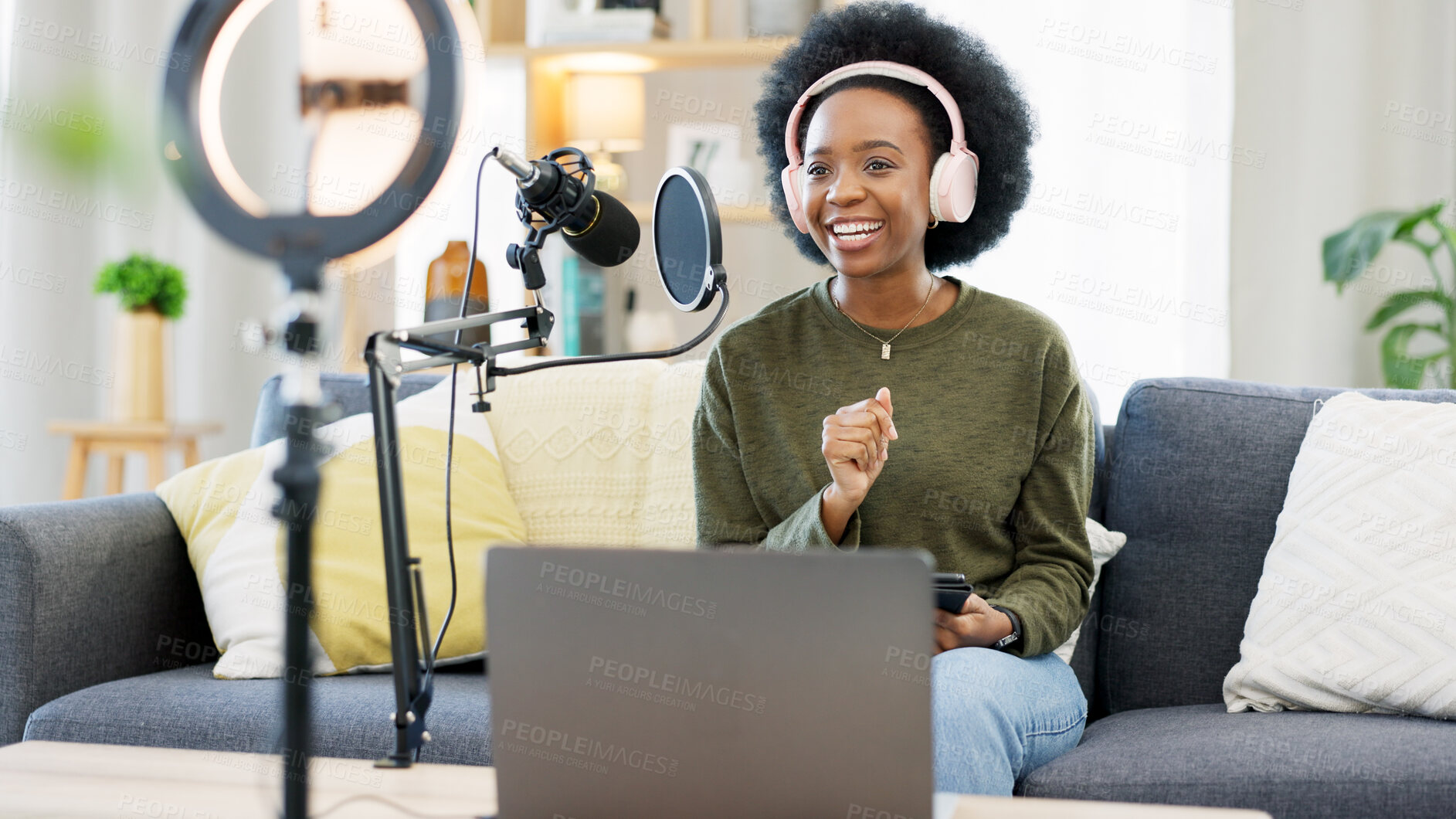 Buy stock photo Headphones, laptop and black woman on microphone in podcast at home in living room of influencer. Technology, smile and content creator on mic for broadcast, communication and radio talk show on sofa