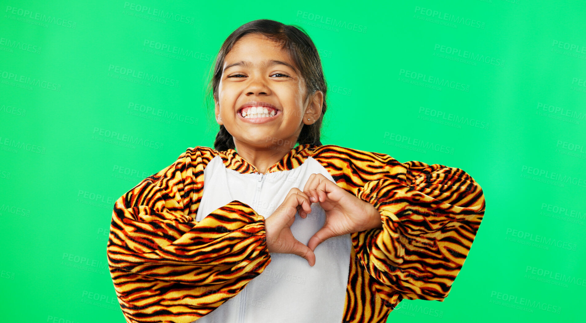 Buy stock photo Girl child, heart sign and green screen with smile, tiger suit pyjamas and love by studio background. Kid, mock up and animal clothes with v icon, emoji and happy with symbol, portrait and kindness