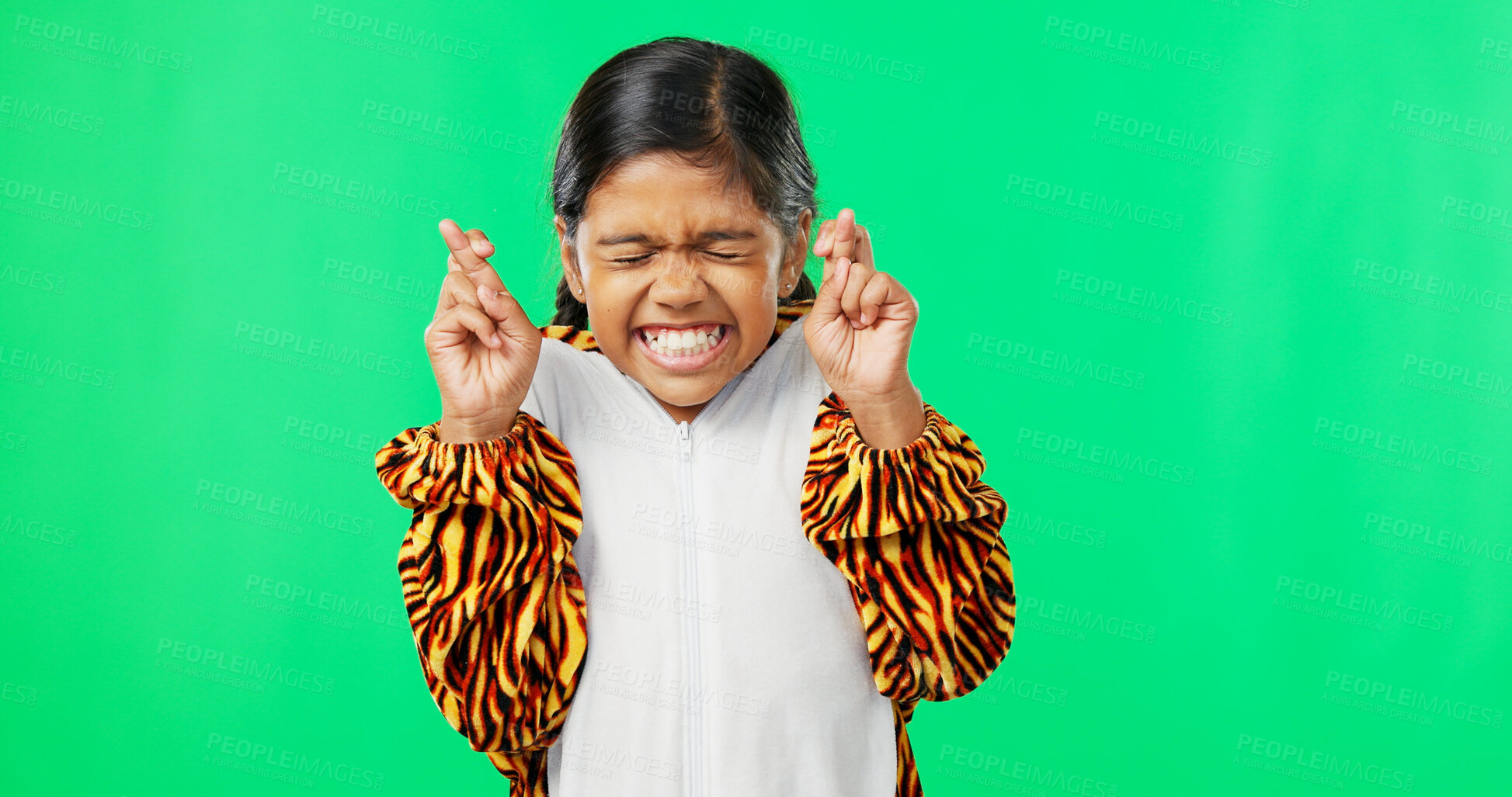 Buy stock photo Hope, excited and face of girl on green screen with hand gesture for wish, good luck and fingers crossed. Emoji, happy and young child in costume with sign for excitement, winning and pray in studio