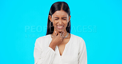Buy stock photo Woman, sore throat and stress in studio for health, allergy and sick by blue background. Indian girl, strep and frustrated for pain, virus and hand on neck for healthcare, wellness and flu symptoms