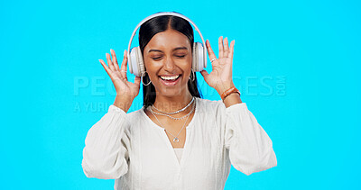 Buy stock photo Happy, woman and music headphones in studio to celebrate party, freedom and hearing audio on blue background. Indian model, smile and listening to multimedia sound, radio and streaming subscription 